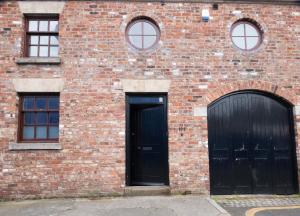 two black doors on a brick building with windows at Spacious house Liverpool city centre L1, sleeps 16 in Liverpool +21 photos