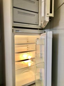 - un réfrigérateur vide avec une porte ouverte dans la cuisine dans l'établissement Charmant Studio Indépendant Le Broc avec parking privé, à Le Broc