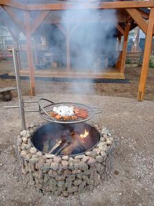 a large fire pit with food cooking in it at Lesne Runo Borsk in Borsk