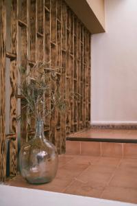a glass vase with a plant in it on a table at Riad Bianca Essaouira Guest House in Essaouira +140 photos
