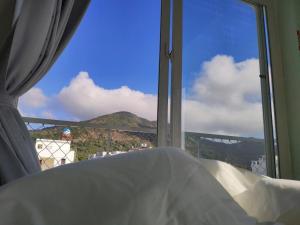 a bedroom with a window with a view of a mountain at Hacoda Homestay in Con Dao