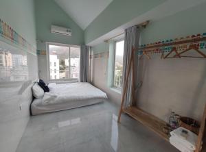 a small bedroom with a bed and a window at Hacoda Homestay in Con Dao