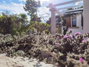 a cross in the middle of a garden with flowers at Villa Peru in Tanaunella