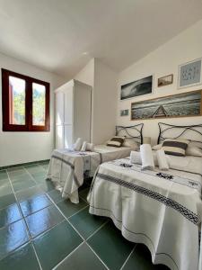 two beds in a room with green tile floors at Villa Peru in Tanaunella