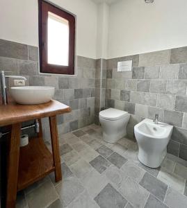 a bathroom with a sink and a toilet at Villa Peru in Tanaunella +6 photos
