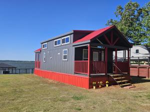 een klein huisje bovenop een veld bij Lake Front Cottage Paradise in Pittsburg