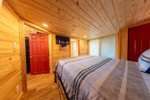een slaapkamer met een bed en een rode deur bij Lake Front Cottage Paradise in Pittsburg