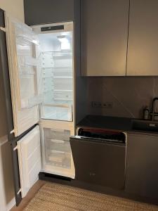 een lege koelkast met de deur open in een keuken bij New Apartment in Kadriorg, Tallinn City Centre in Tallinn