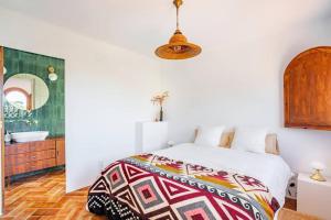 a bedroom with a bed and a bathroom with a sink at ThePineRooms in Arenys de Munt