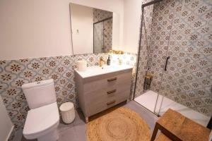 a bathroom with a toilet and a sink at Exquisito apartamento en el centro. in Gandía