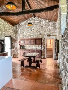 a room with a table in a stone wall at Casa da Eira by Quantique in Amares