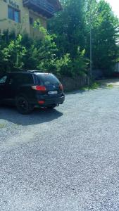 ein schwarzes Auto, das am Straßenrand geparkt ist in der Unterkunft Casa Dora in Sovata