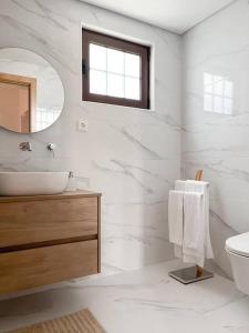 a white bathroom with a sink and a mirror at Casa da Eira by Quantique in Amares +56 photos