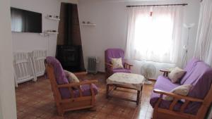 een woonkamer met paarse meubels en een open haard bij Villa en Sa Roca in Es Mercadal