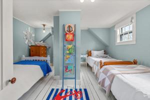 a bedroom with two beds and a clock on the wall at Cozy Large Home in Harwich with Patio near Wequassett Resort in Harwich