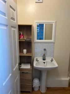 a bathroom with a sink and a mirror at Willows Guest House in Great Yarmouth