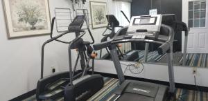 a gym with three tread machines in a room at HomeBridge Inn and Suites in Beaumont