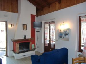 ein Wohnzimmer mit einem Kamin und einem blauen Sofa in der Unterkunft Ferienwohnung in Val Maria-Pur mit Großem Balkon und Seeblick in Pieve Di Ledro