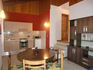 eine Küche mit einem Holztisch und einem Esszimmer in der Unterkunft Ferienwohnung in Val Maria-Pur mit Großem Balkon und Seeblick in Pieve Di Ledro