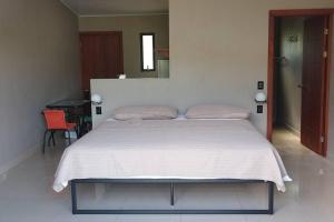 1 dormitorio con 1 cama grande con manta blanca en Cala Ranch Suites, en Quesada