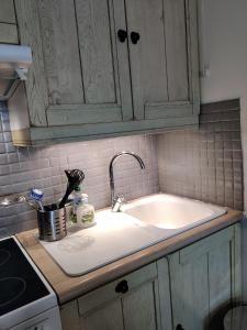 a kitchen counter with a white sink and a counter top at Spacieux appartement refait à NEUF - 4 pers - vue sur l'hippodrome in Cabourg