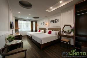 Victory Legend Hotel - In Hanoi Central في هانوي: غرفة فندقية بسريرين ومكتب