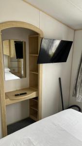 a bedroom with a mirror and a bed and a tv at Caravan home Clacton-On-Sea St Osyth in Saint Osyth +18 photos
