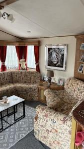 a living room with two couches and a table at Caravan home Clacton-On-Sea St Osyth in Saint Osyth