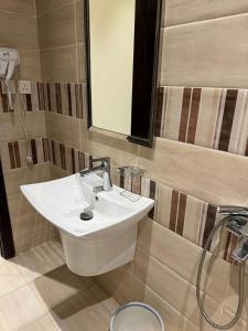 a bathroom with a white sink and a shower at فندق مارينا للاجنحة الفندقيه in Jeddah