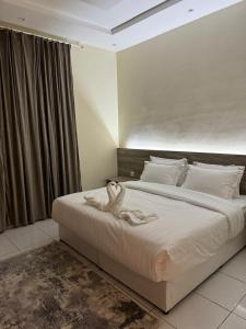 a bedroom with a large white bed with a swan on it at فندق مارينا للاجنحة الفندقيه in Jeddah