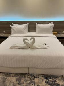 a bed with two swans made to look like hearts at فندق مارينا للاجنحة الفندقيه in Jeddah