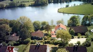 an aerial view of a house next to a lake at Das magische Geschichtenhaus - Einfach wohlfühlen in der Holsteinischen Schweiz in Schönwalde am Bungsberg