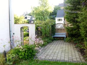 een tuin met een bankje voor een huis bij Landhaus am Bach in Winterberg-Silbach in Winterberg