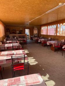 a room filled with tables and chairs with red and white at Дом Отдыха Айзада in Qabanbay