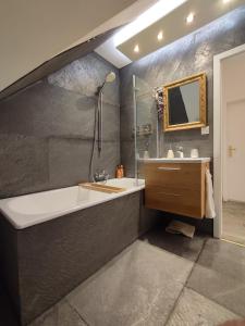 a bathroom with a tub and a sink and a mirror at Villa Schöneck Bad Münster in Bad Kreuznach