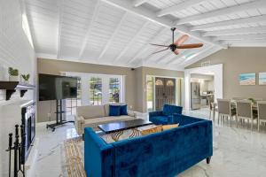 a living room with a blue couch and a ceiling fan at Lovely Villa Home Pool Disney Adventure in Clearwater