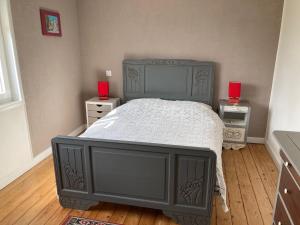 een slaapkamer met een blauw bed en twee rode kaarsen bij La Source de la Liane 