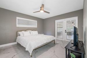 a bedroom with a bed and a flat screen tv at Lovely Villa Home Pool Disney Adventure in Clearwater +45 photos