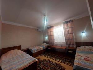 Pokój z 2 łóżkami i oknem w obiekcie NUKUS GUEST HOUSE w Nukus
