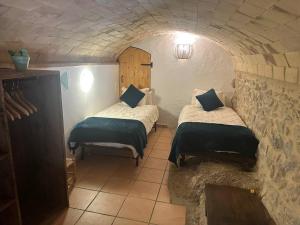 a small room with two beds in a cave at Mas La Cassanya in Terrades