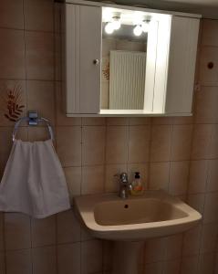a bathroom sink with a mirror and a towel at Thalia`s Apartment near the beach in Nea Kalikratia +11 photos