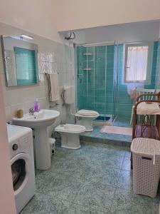 阿尔盖罗Flowered House with garden的浴室设有2个卫生间、水槽和淋浴。