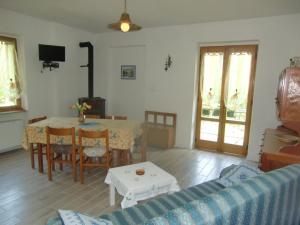 sala de estar con mesa y sofá azul en Sehr geräumige Wohnung umgeben von Natur, en Molina di Ledro