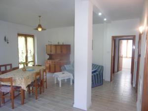 comedor y sala de estar con mesa y sillas en Sehr geräumige Wohnung umgeben von Natur, en Molina di Ledro