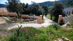 a garden with pink flowers and a sidewalk at Chez Chris et Marie in Les Mages