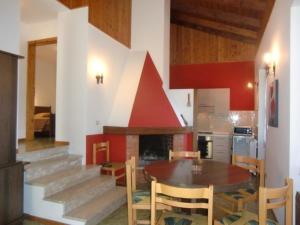 een keuken en eetkamer met een tafel en een open haard bij Appartement in Val Maria-Pur mit Großem Balkon und Seeblick in Pieve Di Ledro