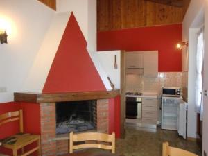 een keuken met een open haard en een rood dak bij Appartement in Val Maria-Pur mit Großem Balkon und Seeblick in Pieve Di Ledro
