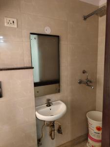 uma casa de banho com um lavatório e um espelho em Hotel Living Rooms- BY Hotel Green Snapper em Nova Deli