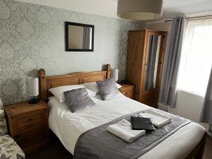 a bedroom with a bed with two towels on it at Willows Guest House in Great Yarmouth