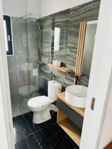 a bathroom with a toilet and a sink at Grand Villa Caciulata in Caciulata